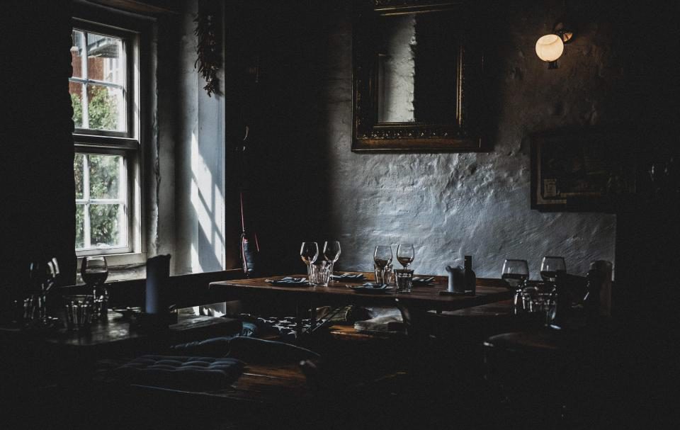 Comedor del restaurante con las mesas puestas y luz cálida